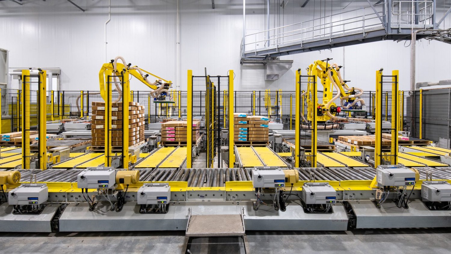 Twin robotic palletizing cells arranged in a cellular layout inside a high-volume manufacturing facility