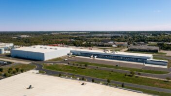 Aerial view of large industrial distribution buildings with truck courts and parking surrounded by open land