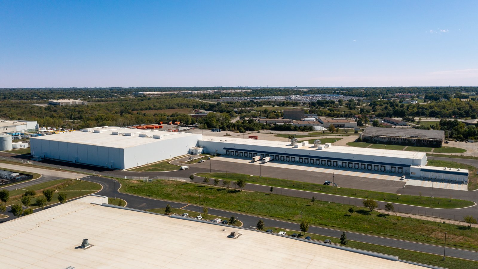 Aerial view of large industrial distribution buildings with truck courts and parking surrounded by open land